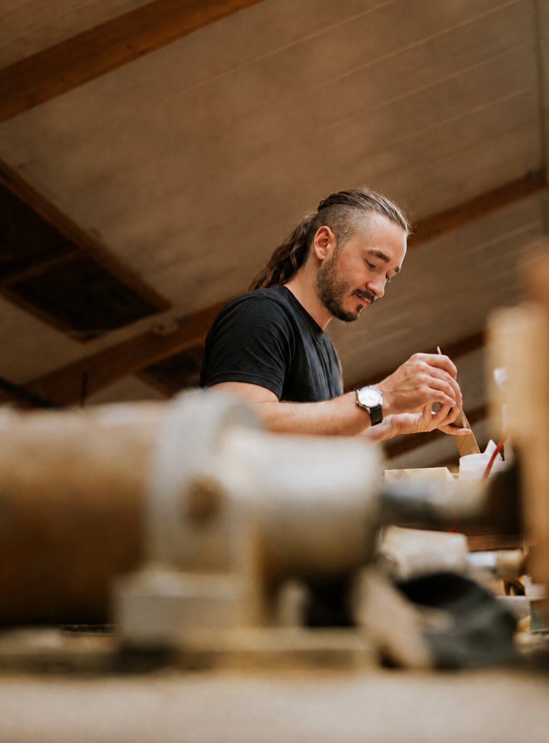 Craftsman finishing a handmade wooden guitar stand in the workshop