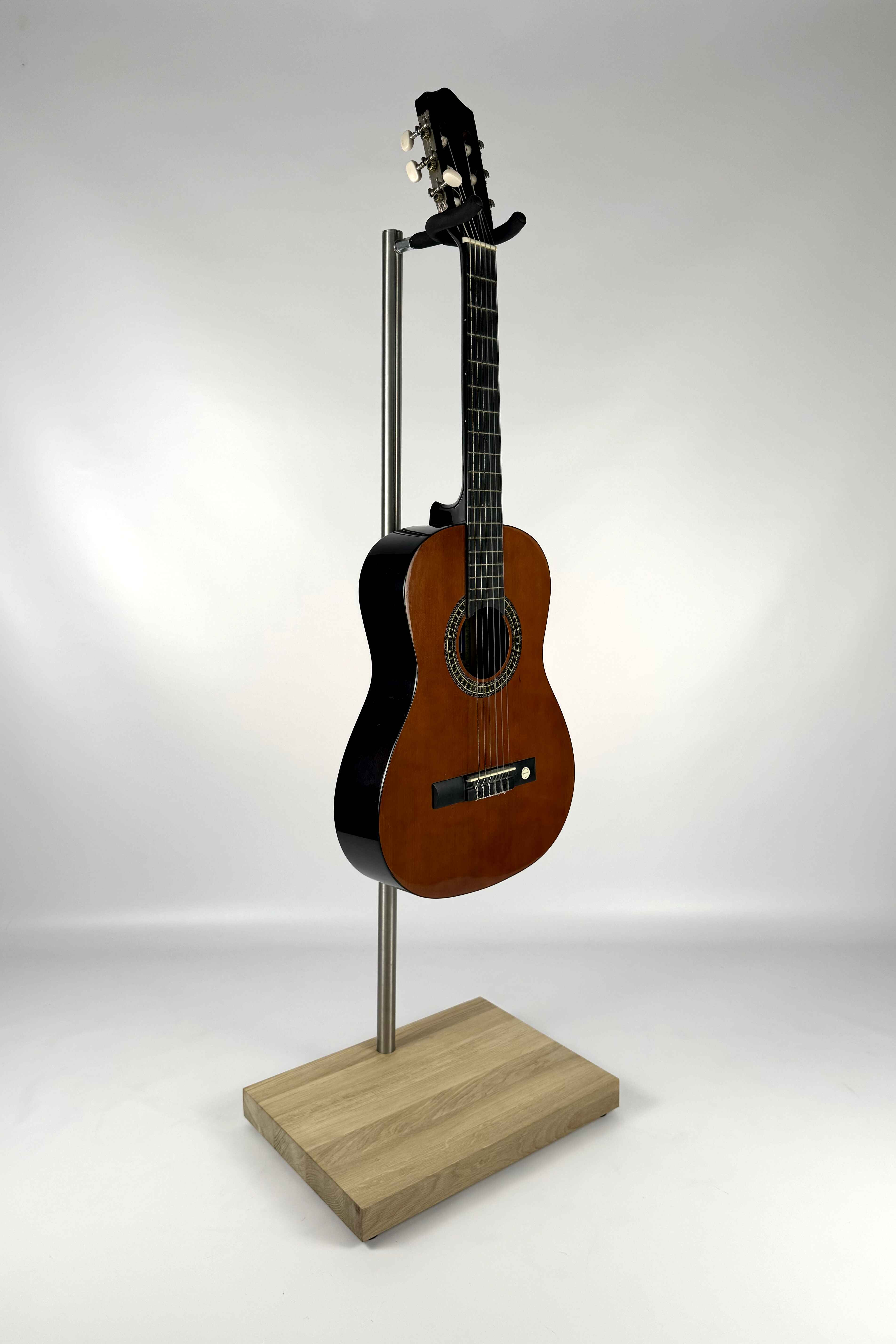 Stable premium handcrafted wooden acoustic guitar stand, with a natural wood finish, holding an acoustic guitar, three-quarter view