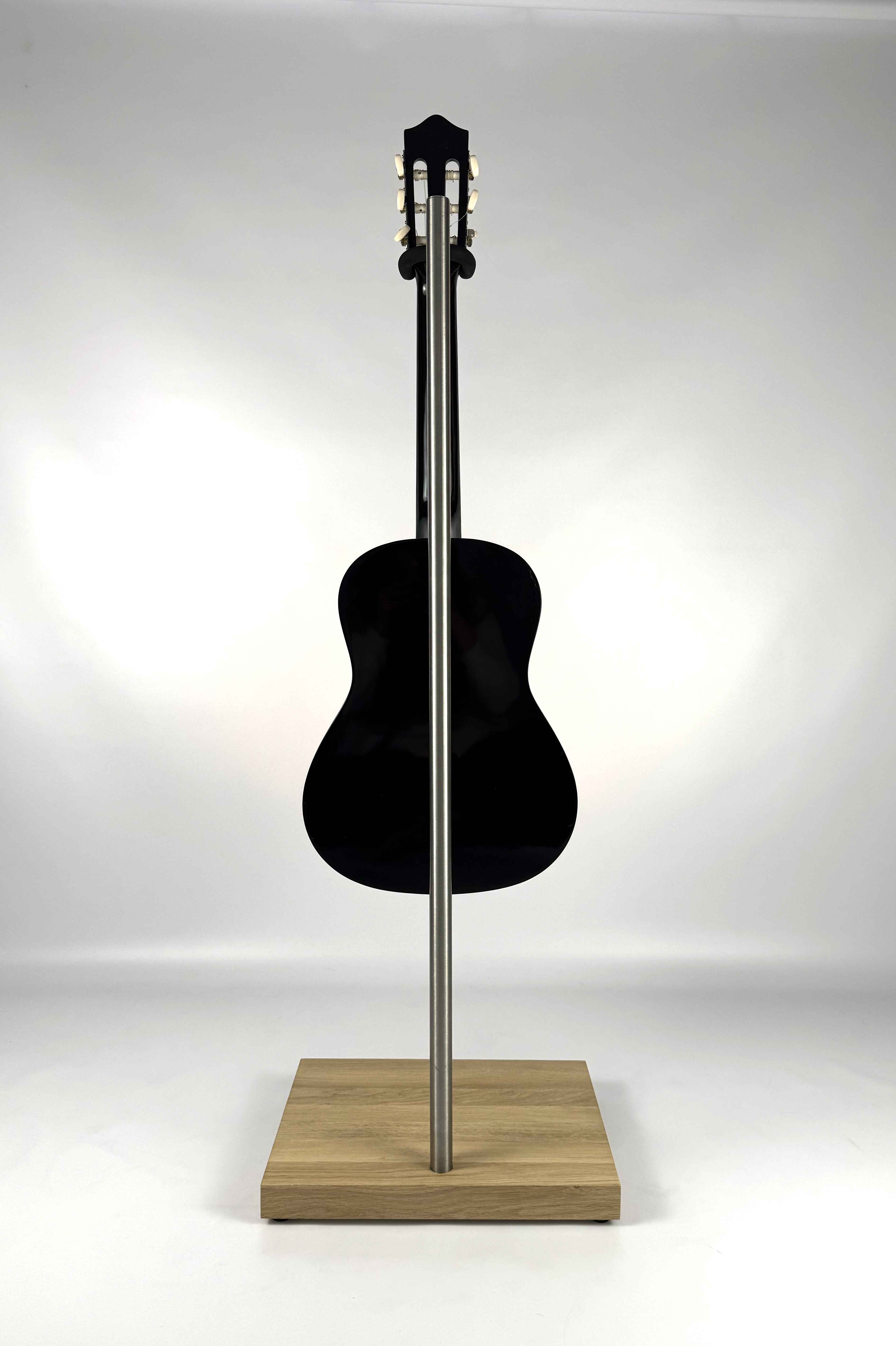 Handcrafted wooden guitar stand with a natural finish holding a guitar, rear view