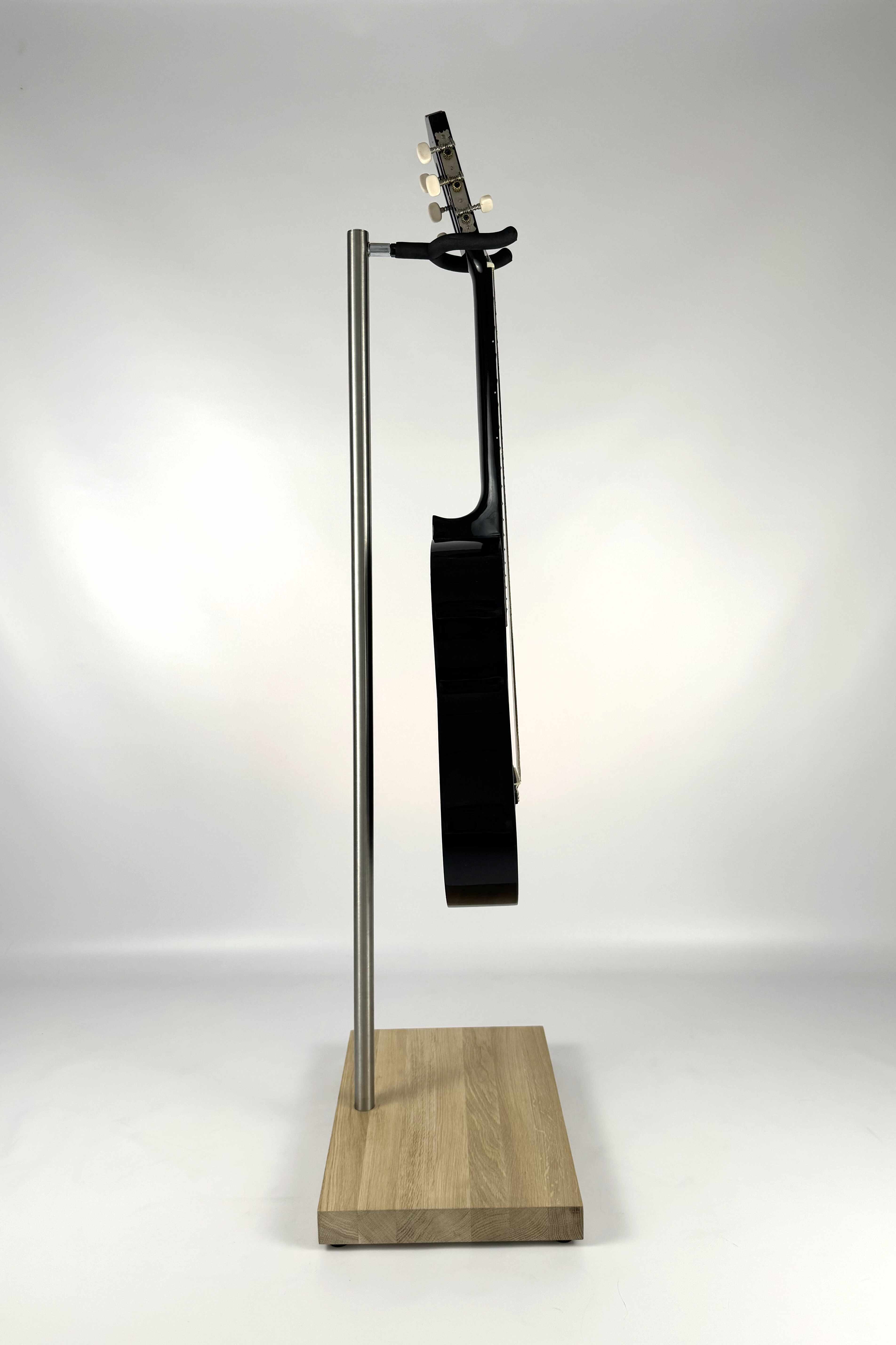 Stable wooden guitar stand with a natural finish holding a guitar, side view showing secure instrument support