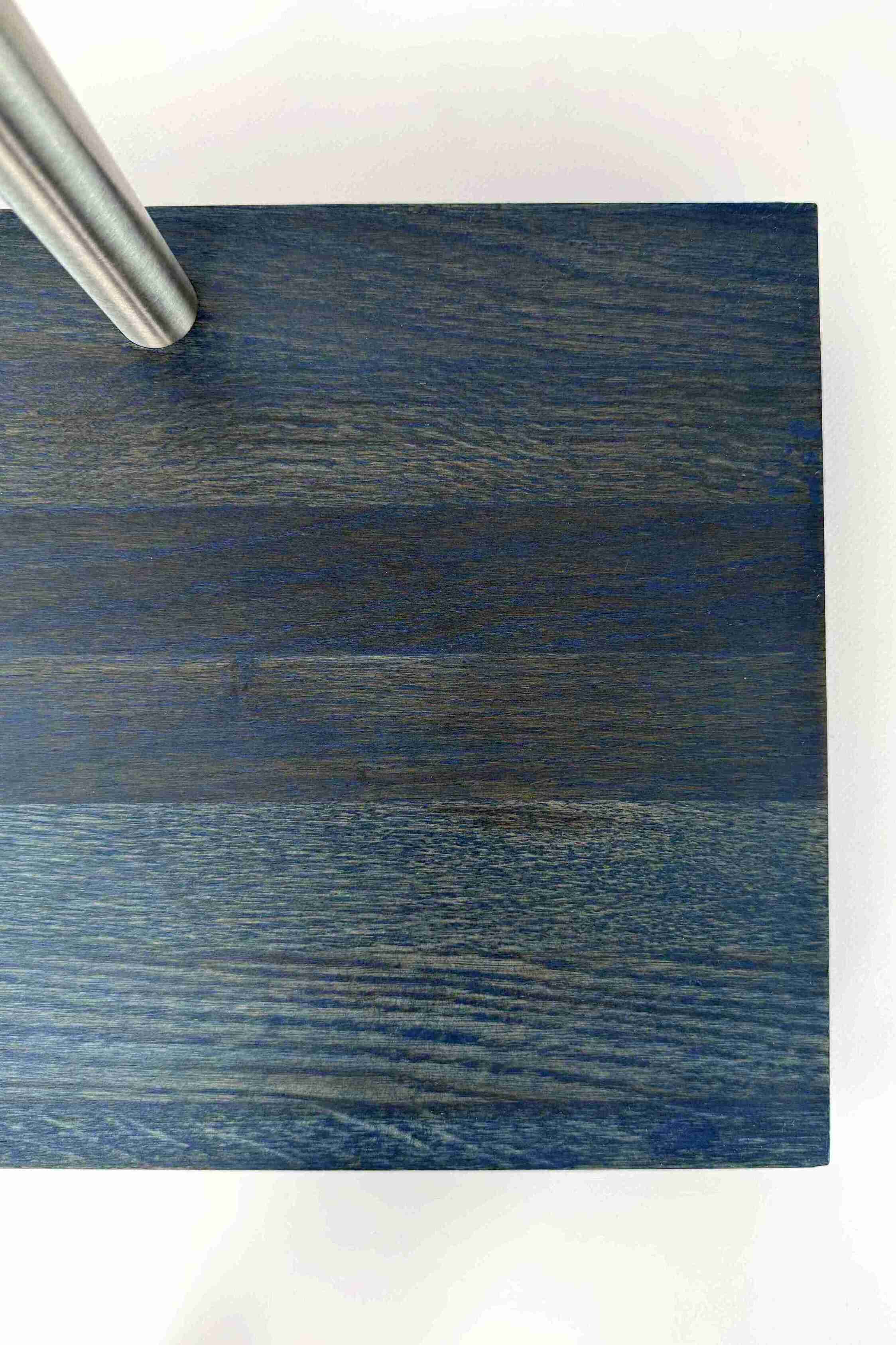 Close-up of the stable base of a premium wooden guitar stand with a blue finish