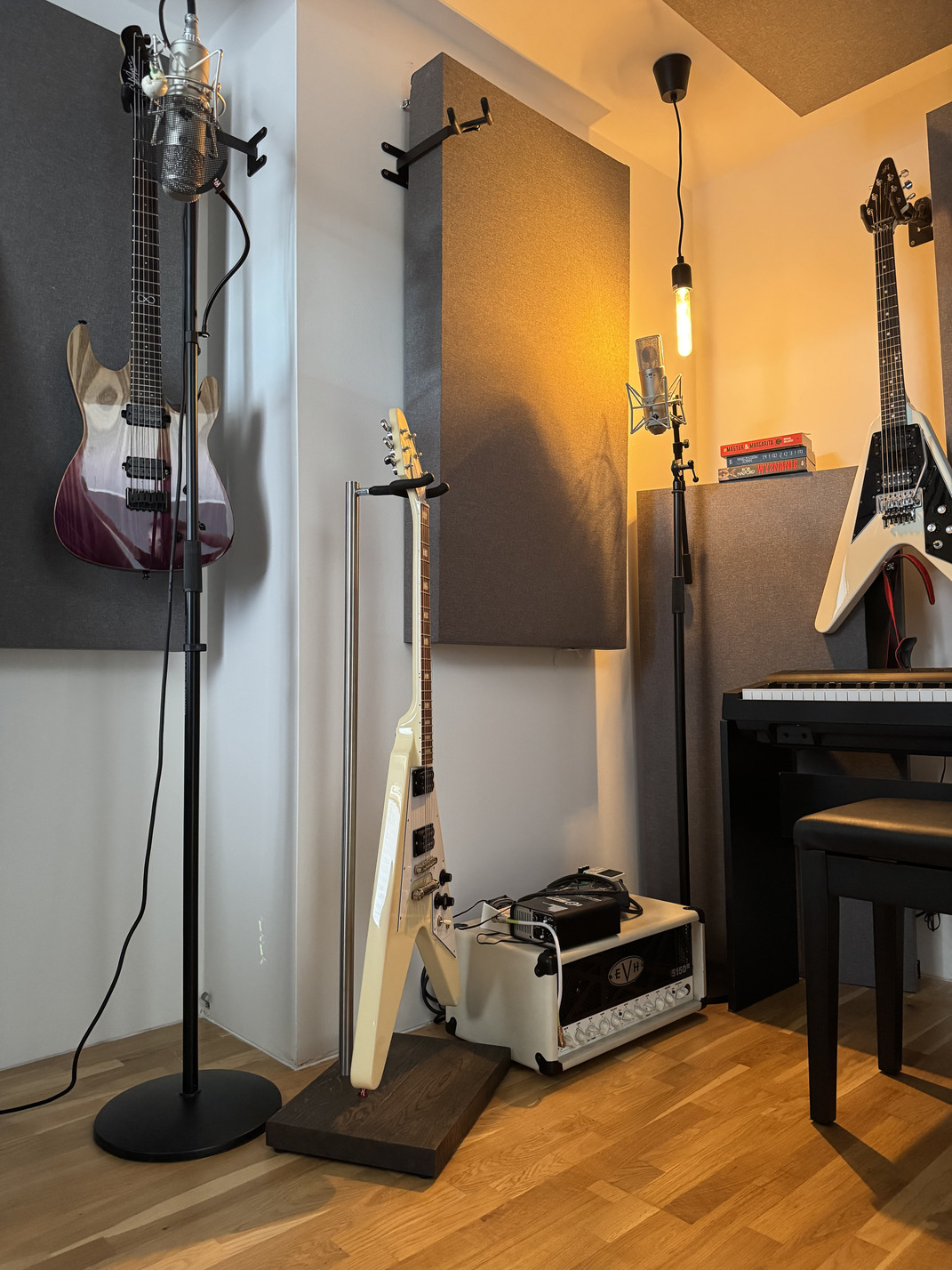 Premium handmade guitar stand with a solid wood base holding a cream electric guitar in a professional recording studio.